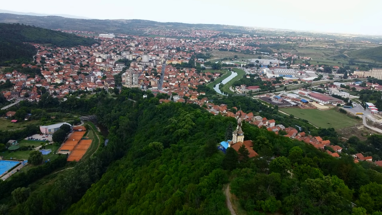 Pogled iz vazduha na Prokuplje sa rekom Toplicom, kućama i zelenim brdom Hisar u prvom planu